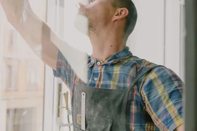 An installer seen through the glass while assembling a window frame