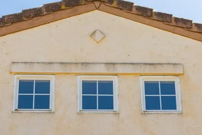 The facade of a house showing three evenly spaced windows